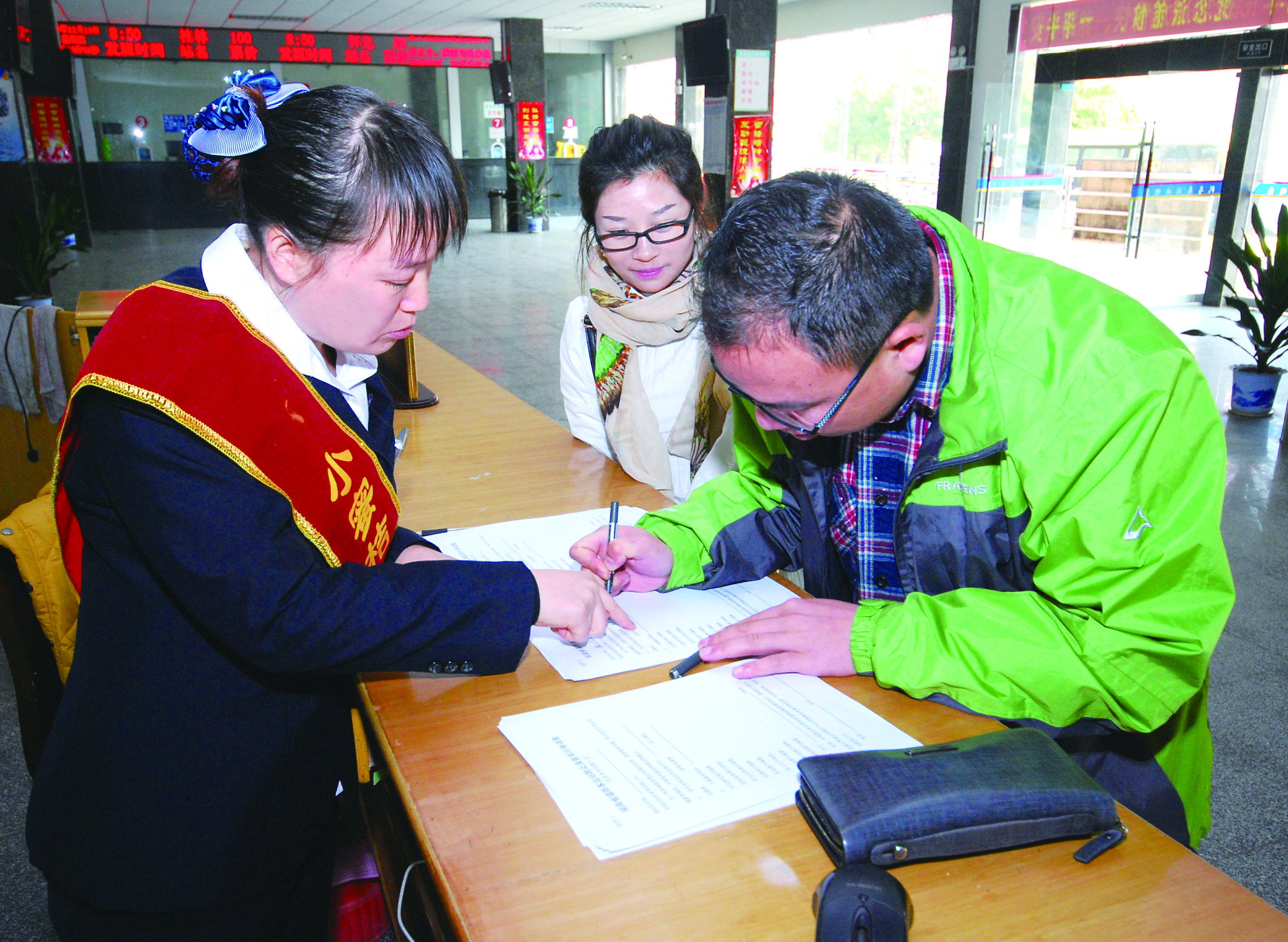 圖為洞口汽車(chē)總站站務(wù)人員在熱心為旅客服務(wù)。